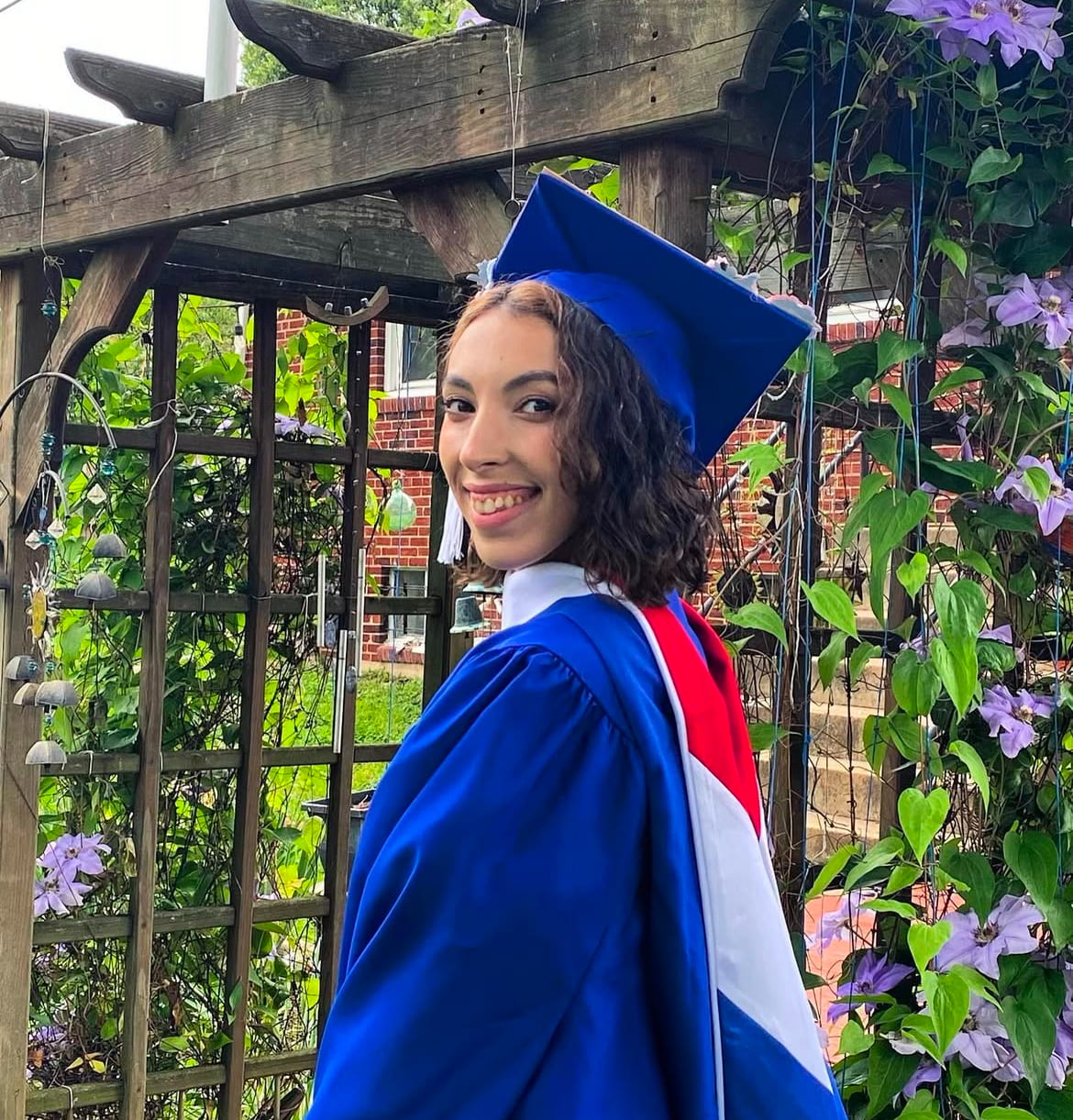Smiling young person in American University Master's Art History graduation robes.